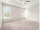 Spacious carpeted main bedroom with a ceiling fan, tray ceiling, and two windows that provides ample natural light at 503 Goldfinch Way, Stockbridge, GA 30281