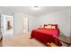 Spacious bedroom with red coverlet, rocking chair, and access to bathroom at 6068 Magnolia Rdg, Stone Mountain, GA 30087