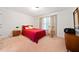 Bedroom with red coverlet, rocking chair, and light-filled window with drapery at 6068 Magnolia Rdg, Stone Mountain, GA 30087