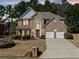 Charming two-story brick home featuring a manicured lawn and attached two-car garage at 6068 Magnolia Rdg, Stone Mountain, GA 30087