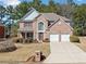 Charming two-story brick home featuring a manicured lawn and attached two-car garage at 6068 Magnolia Rdg, Stone Mountain, GA 30087