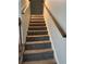 Carpeted staircase with wooden handrails provides access to upper level at 866 Indian Lake Nw Dr, Lilburn, GA 30047