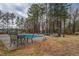 Backyard features a pool, patio furniture, and mature trees at 2375 Gum Creek Rd, Oxford, GA 30054