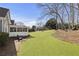 Large backyard with a covered patio, well-kept lawn, and picturesque views of the surrounding landscape at 3825 Bishops Walk, Cumming, GA 30041