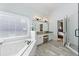 Luxurious bathroom with soaking tub, walk-in shower, double vanity, and wood plank tile floor at 3825 Bishops Walk, Cumming, GA 30041