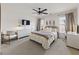 Stylish bedroom with a ceiling fan, plush bedding, modern furniture, and soft natural light at 3825 Bishops Walk, Cumming, GA 30041