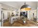 Open concept kitchen with granite counters, breakfast bar, and adjacent dining area with a grand chandelier at 3825 Bishops Walk, Cumming, GA 30041