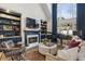 Cozy living room with a fireplace, built-in shelving, piano, and a large window providing ample natural light at 3825 Bishops Walk, Cumming, GA 30041