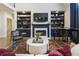 Comfortable living space with a fireplace, bookshelves, a grand piano, and a plush seating area with a stylish rug at 3825 Bishops Walk, Cumming, GA 30041
