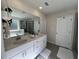 Bright bathroom featuring double sinks, white cabinetry, and a large mirror at 4161 Dean Grove Way, Loganville, GA 30052