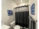 Stylish bathroom featuring a shower with a black curtain and nautical-themed wall decorations at 4161 Dean Grove Way, Loganville, GA 30052