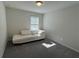 Minimalist bedroom featuring a modern chaise lounge and natural light from the window at 4161 Dean Grove Way, Loganville, GA 30052