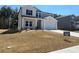 Well-manicured two-story home featuring a two-car garage, inviting entrance, and manicured lawn at 4161 Dean Grove Way, Loganville, GA 30052