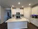 Well-lit kitchen with stainless steel appliances, white cabinets, and a center island at 4161 Dean Grove Way, Loganville, GA 30052