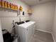 Functional laundry room with washer, dryer, and shelving for storage at 4161 Dean Grove Way, Loganville, GA 30052