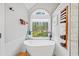 Bright bathroom with a freestanding tub, large window with a wooded view, and a stylish towel rack at 759 Reeves Lake Sw Dr, Marietta, GA 30064