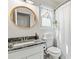 Cozy bathroom with a granite vanity top, round mirror, and a shower with white curtain at 759 Reeves Lake Sw Dr, Marietta, GA 30064