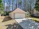 Side view of home with two-car garage, driveway, manicured lawn and mature trees at 759 Reeves Lake Sw Dr, Marietta, GA 30064