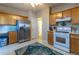 Functional kitchen featuring stainless steel appliances, white backsplash, and wooden cabinets at 1062 Glen Chase Dr, Lawrenceville, GA 30044