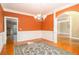 Dining room featuring vibrant orange walls, white wainscoting, and hardwood flooring at 145 Windward Hls, Mcdonough, GA 30253