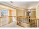 Upstairs hallway with natural light and wood railing overlooking the foyer at 145 Windward Hls, Mcdonough, GA 30253