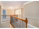 Upstairs hallway with hardwood railing and views to the foyer below at 145 Windward Hls, Mcdonough, GA 30253