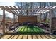 Relaxing pergola with cushioned seating and dining table, set on a artificial lawn with a grill at 412 Ashwood Sw Ave, Atlanta, GA 30315