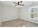 This bedroom features neutral carpet, fan with lights and natural light from a window at 885 Clairidge Ln, Lawrenceville, GA 30046