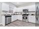 This kitchen is equipped with stainless steel appliances, granite countertops, and white cabinets at 885 Clairidge Ln, Lawrenceville, GA 30046