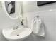 Powder room featuring a pedestal sink with chrome faucet, oval mirror, and tiled walls at 885 Clairidge Ln, Lawrenceville, GA 30046