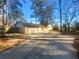Charming one-story home with a wide driveway, two car garage, a brick entryway and beautiful trees at 2217 Troutdale Dr, Decatur, GA 30032