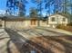 Charming one-story home with a wide driveway, two car garage, a brick entryway and beautiful trees at 2217 Troutdale Dr, Decatur, GA 30032