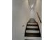 This stairway has dark wood stairs, white risers, and a handrail going up to the next level with white walls at 2217 Troutdale Dr, Decatur, GA 30032