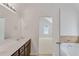 Bathroom with dual sink vanity, large mirror, and open doorway to bedroom and bathtub at 1765 Stone Meadow Rd, Lithonia, GA 30058