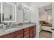 Bright bathroom features double vanity with granite countertop and illuminated mirrors at 2755 Turning Leaf Dr, Lawrenceville, GA 30044