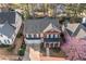 An aerial view of a neighborhood showcasing a traditional two-story brick home with well-maintained landscaping at 1545 Heritage Trl, Roswell, GA 30075