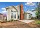 Backyard view with brick chimney, patio, neutral siding, and partial blooming tree at 1545 Heritage Trl, Roswell, GA 30075