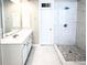 Modern bathroom featuring a walk-in shower with marble-like tile and a double sink vanity at 1545 Heritage Trl, Roswell, GA 30075