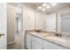 A well-lit bathroom featuring a granite countertop, dual sinks, white cabinets, and access to the hallway at 1545 Heritage Trl, Roswell, GA 30075