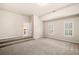 Bedroom featuring a raised area with steps, neutral walls, and two bright shuttered windows at 1545 Heritage Trl, Roswell, GA 30075