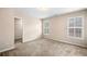 A bright bedroom is shown with neutral walls, carpet, two windows with shutter blinds, and walk-in closet at 1545 Heritage Trl, Roswell, GA 30075