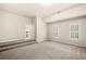Large bonus room with carpet, neutral colored walls, natural light from two windows and a door at 1545 Heritage Trl, Roswell, GA 30075