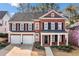 Beautiful two-story red brick home featuring black shutters, a covered porch, and manicured landscaping at 1545 Heritage Trl, Roswell, GA 30075