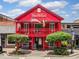 Charming two-story red building with flags and outdoor seating offers an inviting and vibrant street presence at 1545 Heritage Trl, Roswell, GA 30075