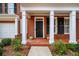 Inviting front porch with brick flooring, white columns, and a black front door at 1545 Heritage Trl, Roswell, GA 30075