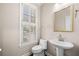 Charming half-bathroom featuring pedestal sink, toilet, and a window with plantation shutters at 1545 Heritage Trl, Roswell, GA 30075