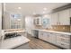 Sunlit kitchen with white cabinets, modern appliances, bar seating, and hardwood floors at 1545 Heritage Trl, Roswell, GA 30075