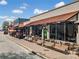 Street view featuring restaurant facades with outdoor seating areas, benches, and awnings at 1545 Heritage Trl, Roswell, GA 30075