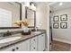 Bathroom with double sinks, granite countertops, and decorative animal prints in hall at 188 Harmony Woods Dr, Dallas, GA 30157