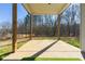 Covered patio with green turf area, wooden support beams and view of trees at 188 Harmony Woods Dr, Dallas, GA 30157